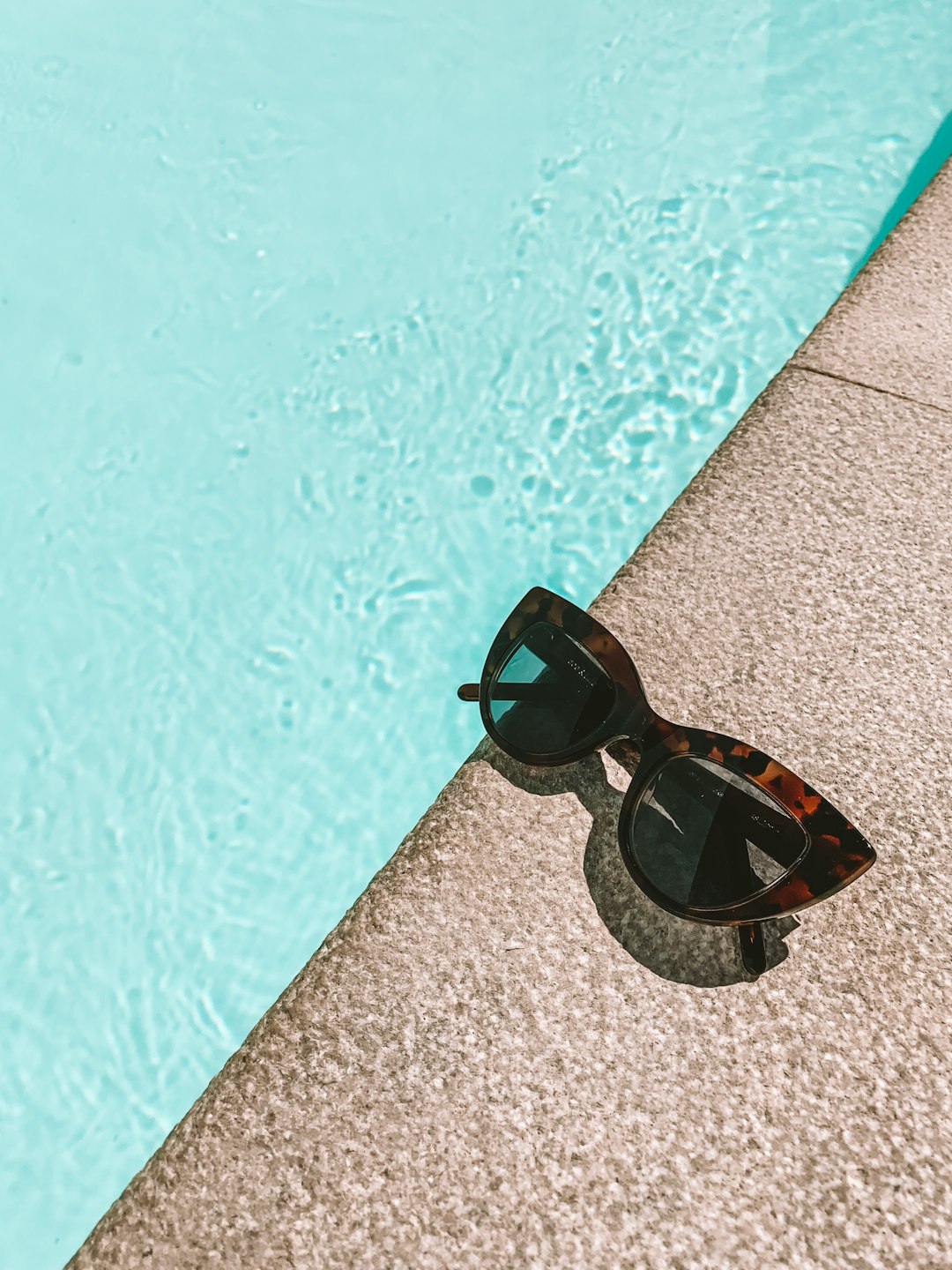 black-and-brown-sunglasses-beside-the-swimming-pool-v4pktt-0-mi