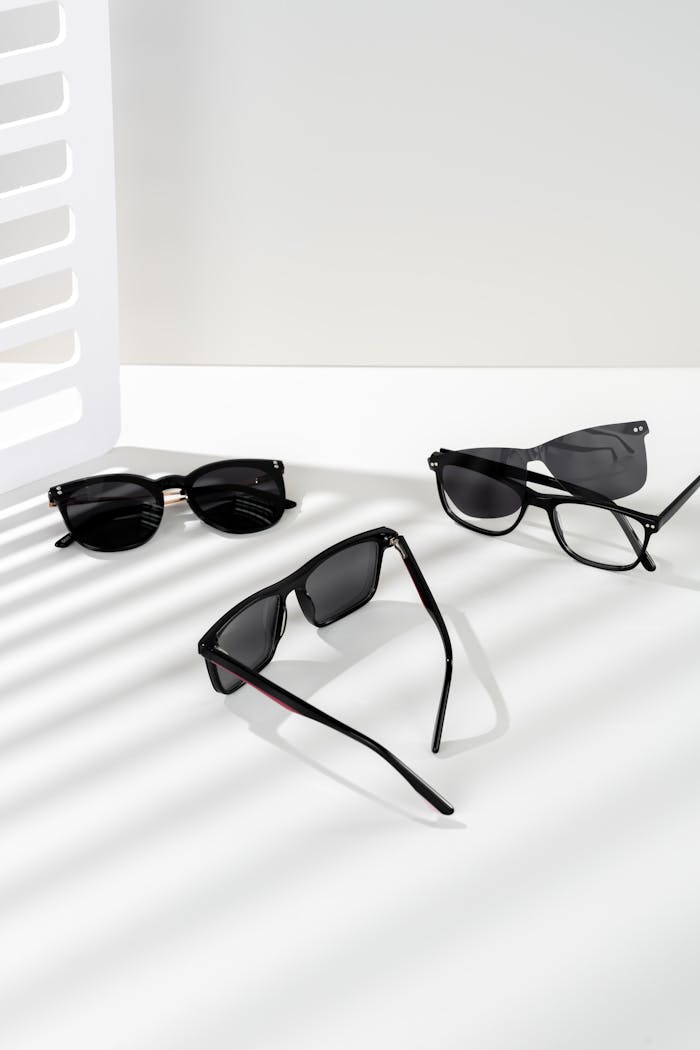 Array of stylish sunglasses on a white background with artistic shadows.